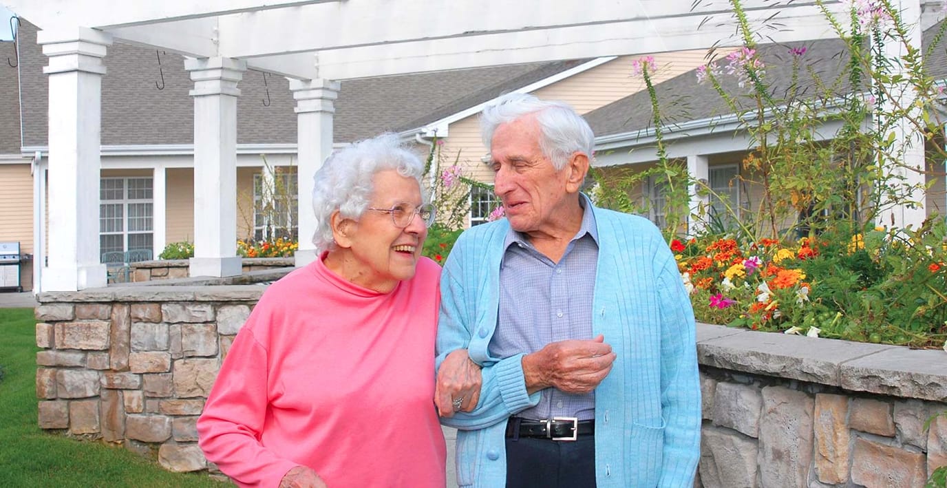 Couple walking together outside in a garden area