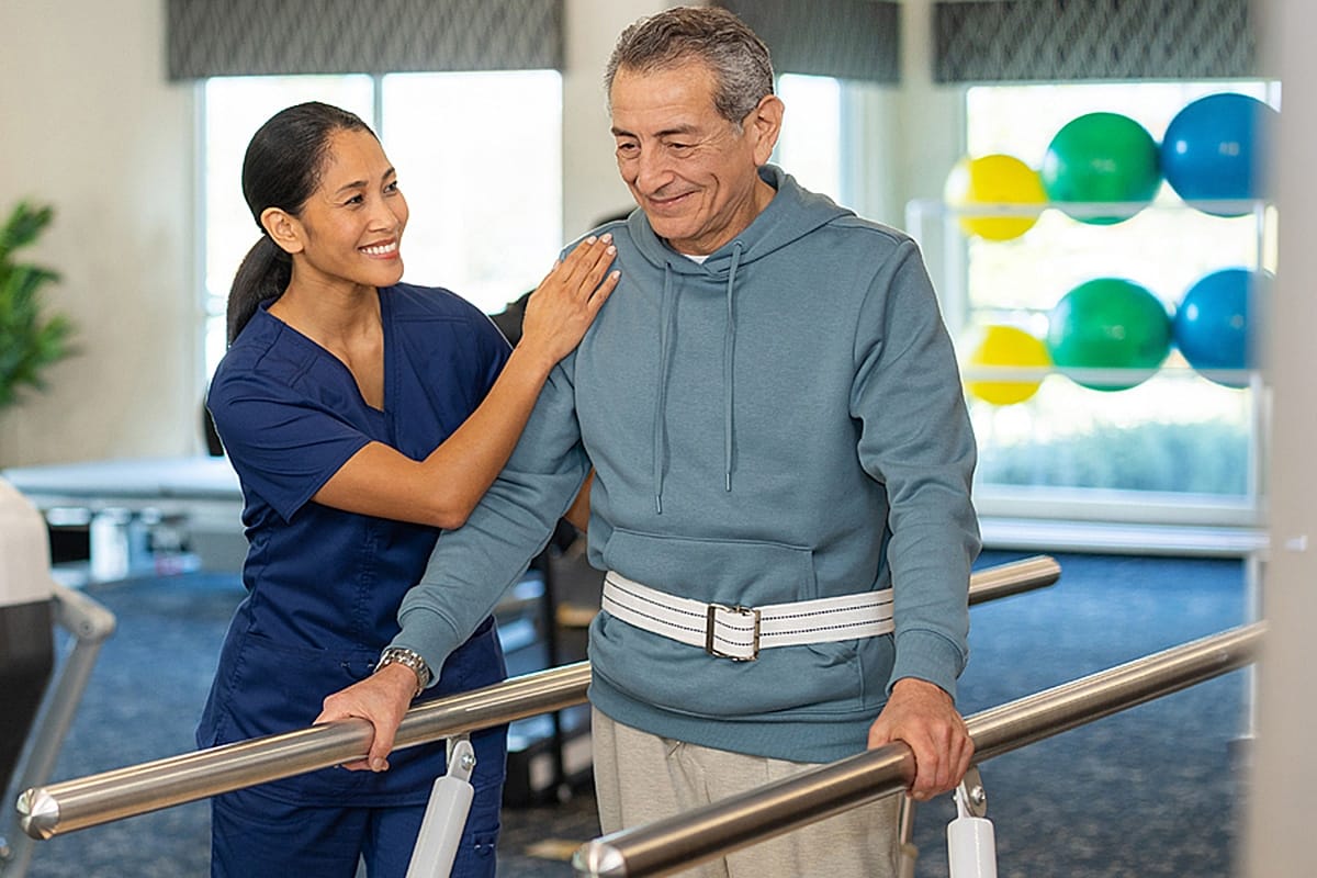 Cascade Terrace Post Acute, Nursing Home in Portland, OR — Therapist assisting a resident with mobility exercises