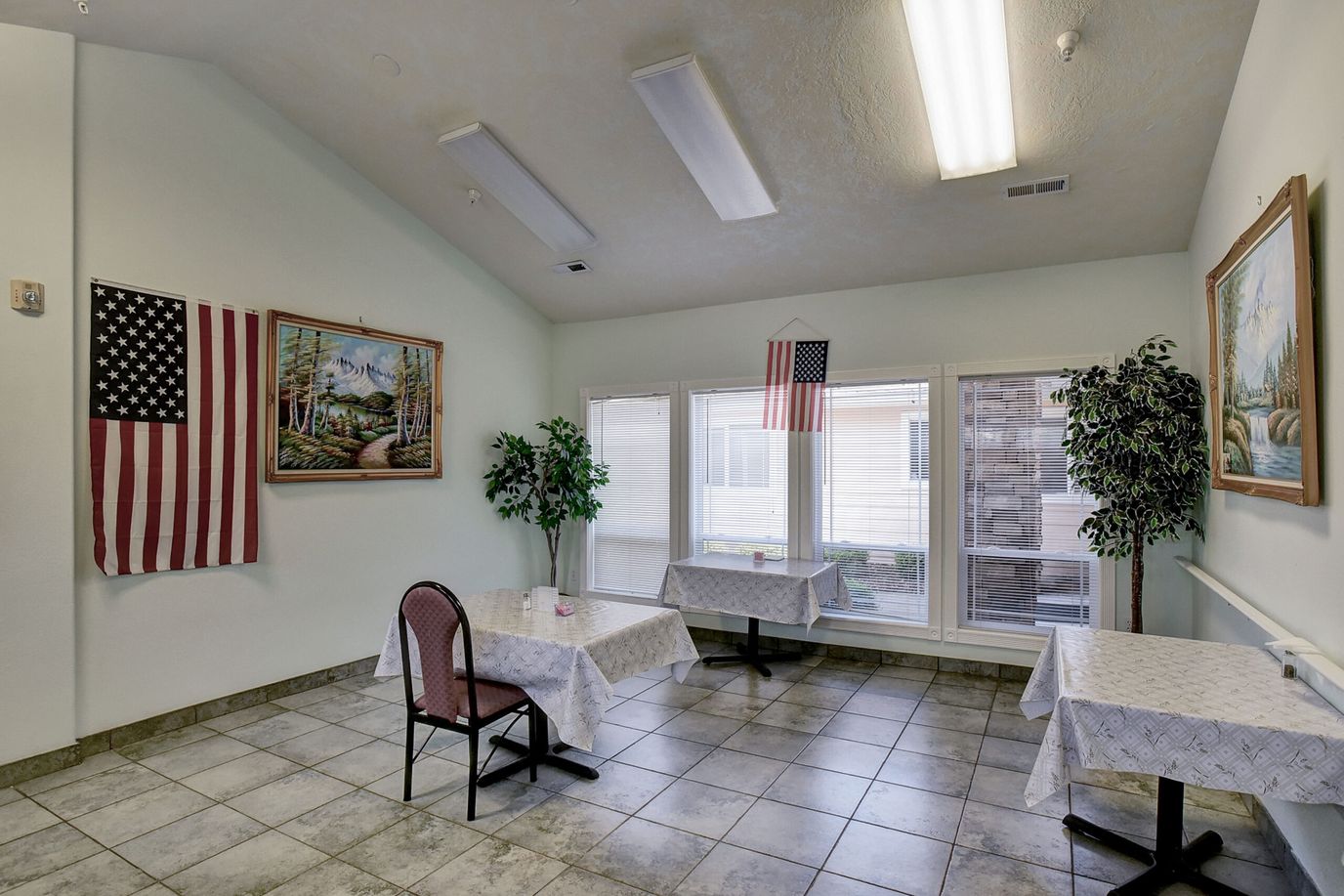 Bright common area with tables and American flags