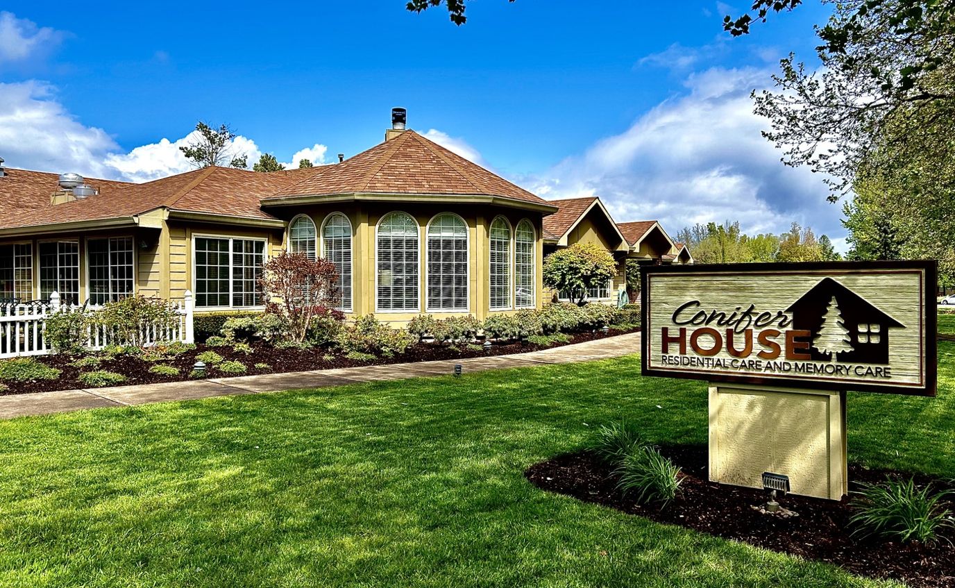 Exterior view of Conifer House Residential Care with landscaped grounds