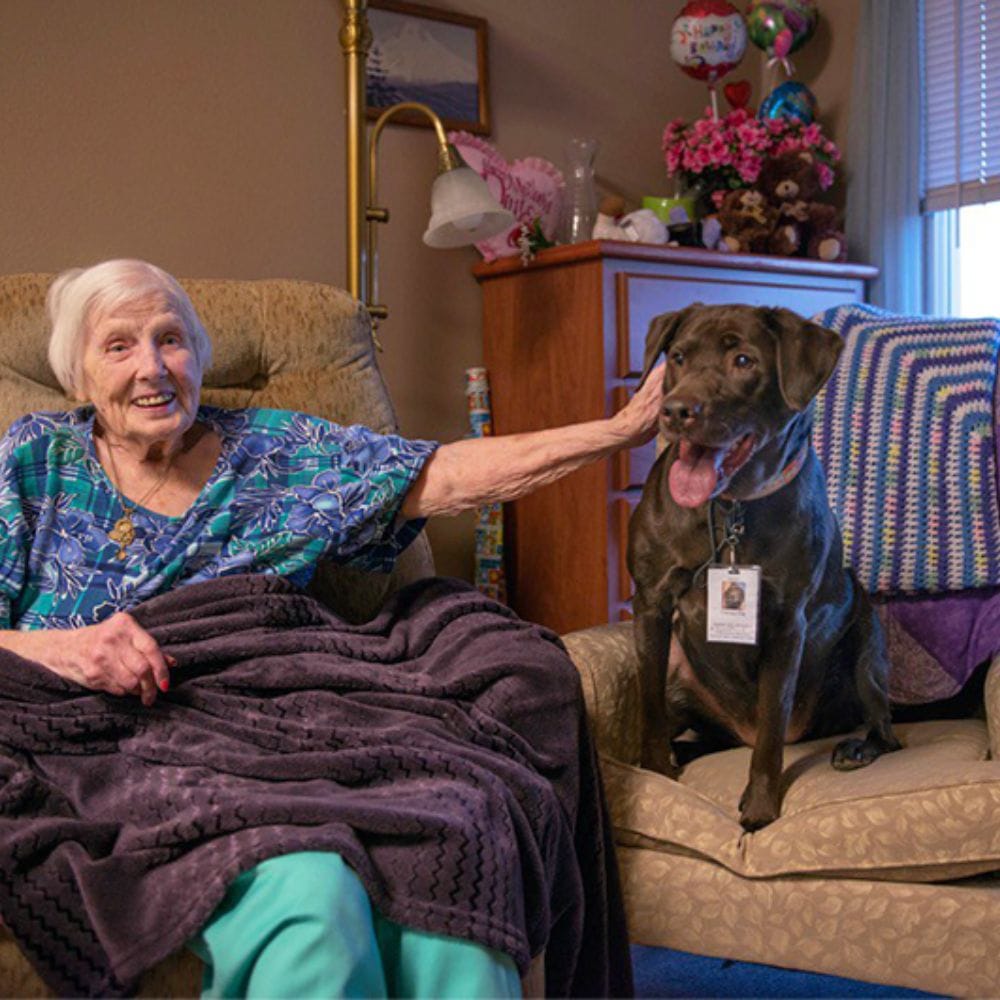 Resident enjoying time with a dog in a cozy setting
