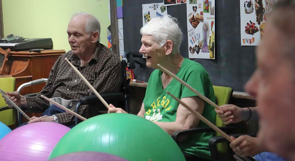 Residents participating in a drumming activity in a common area