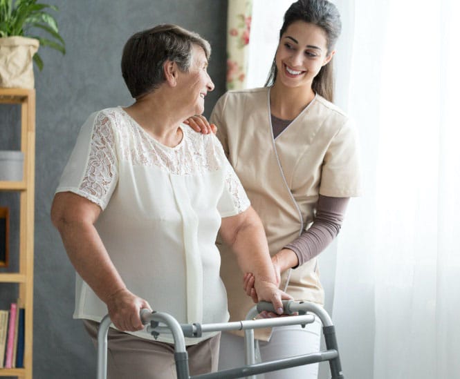 A caregiver assisting a resident with a walker