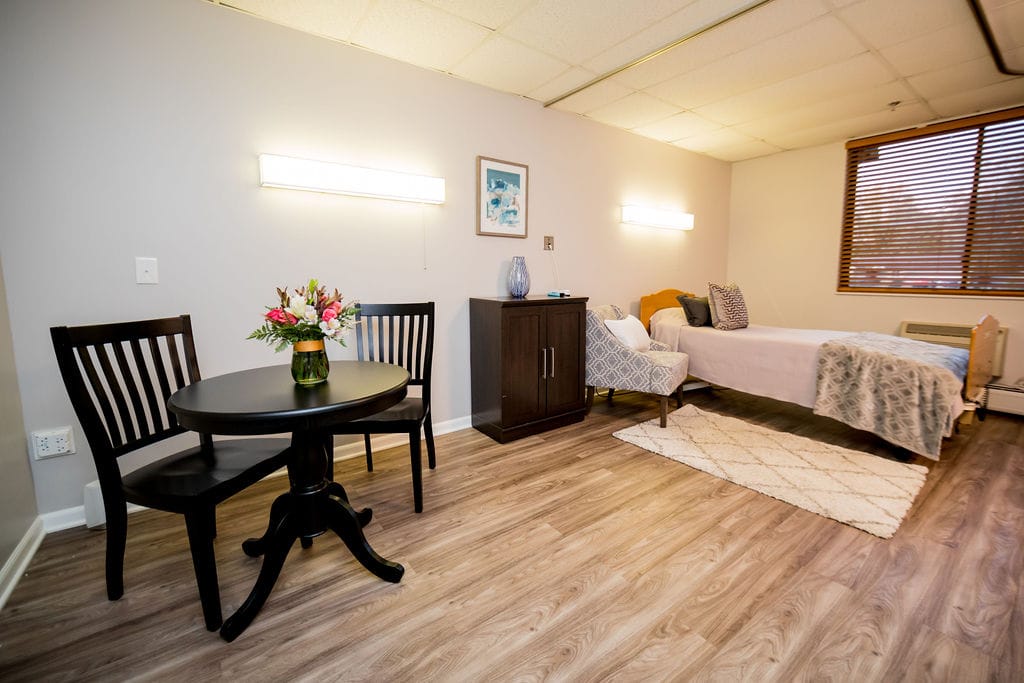 Cozy resident room with a bed and small dining table