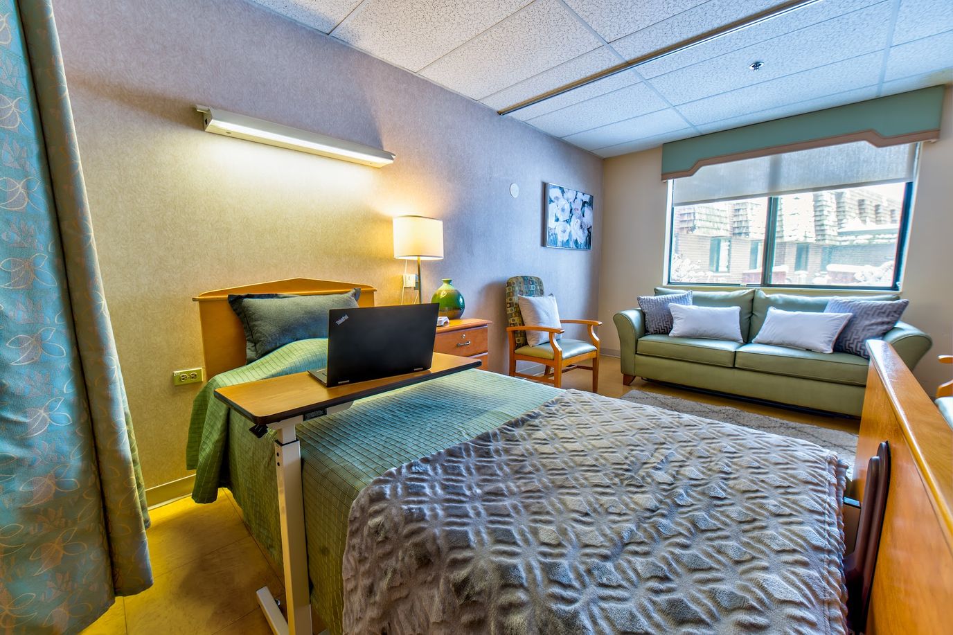 Brightly lit resident room with bed and seating area