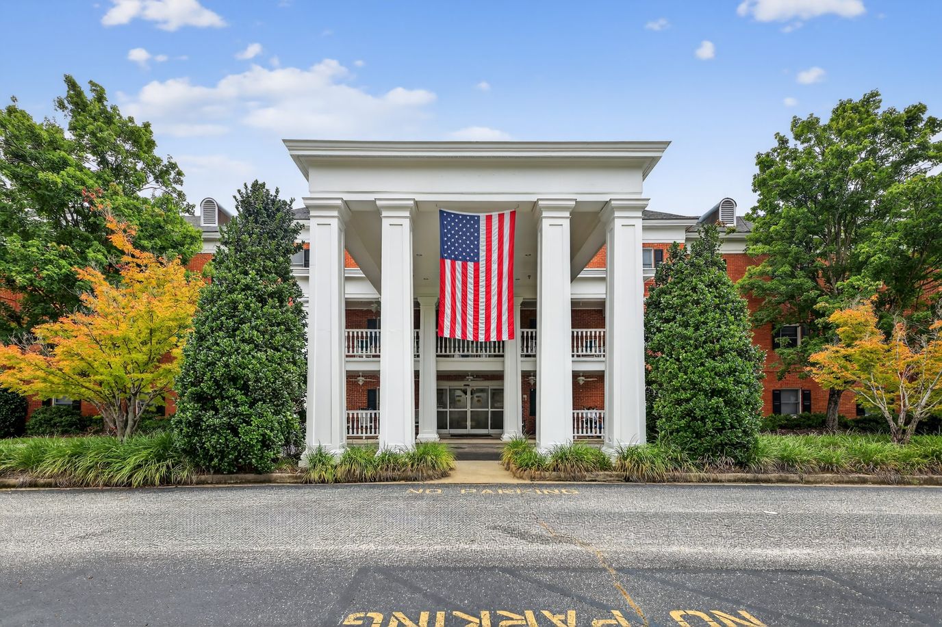 Exterior view of a senior living facility with American flag