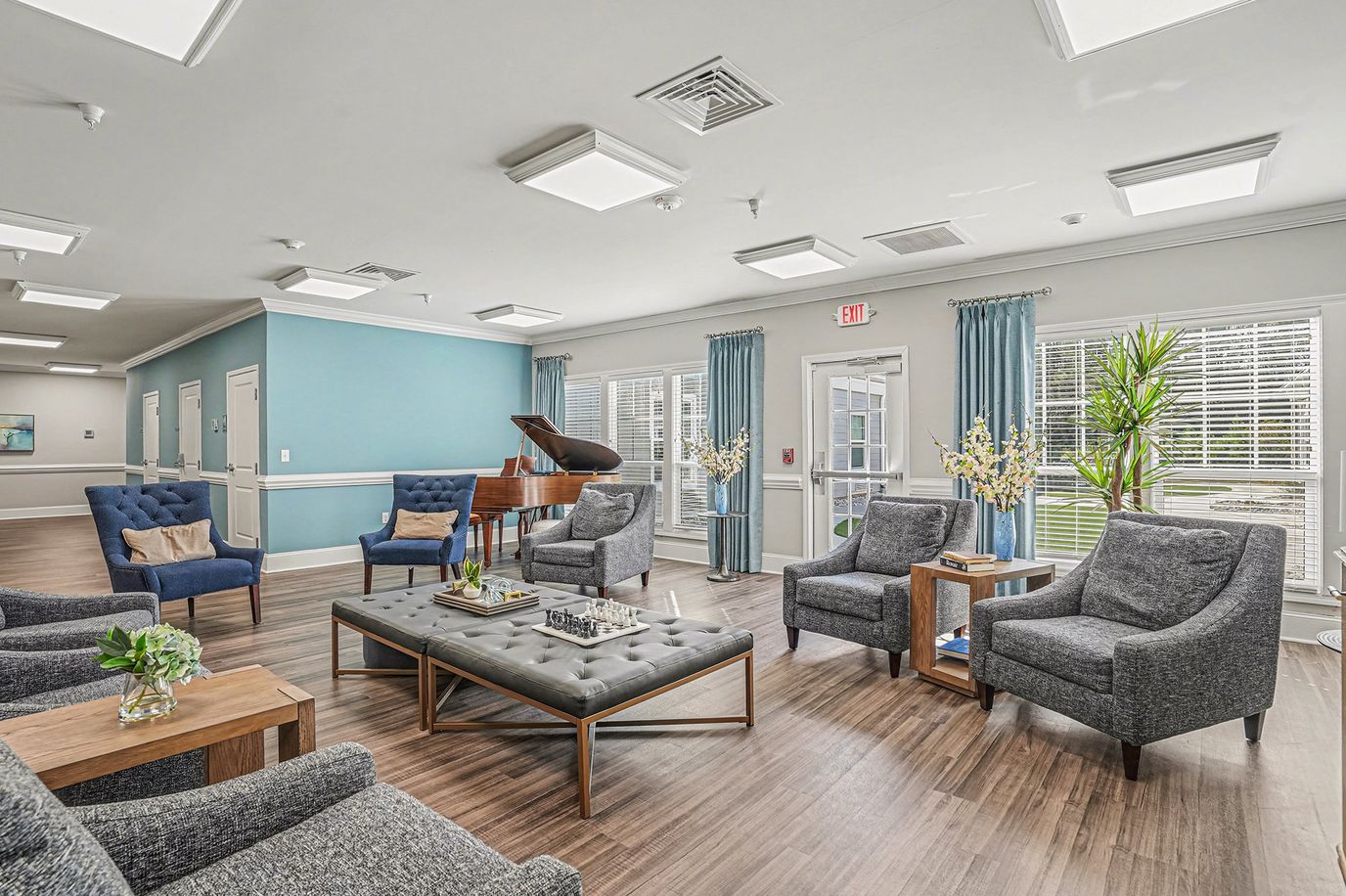 Bright common area with seating and a piano