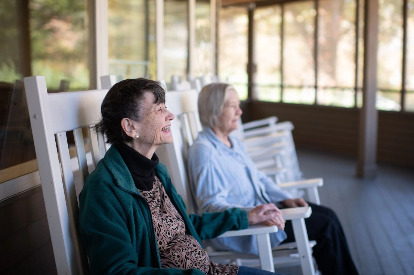 Apple Grove Alzheimer’s and Dementia Residence, assisted living in Memphis, TN — Two elderly women sitting on rocking chairs on a porch