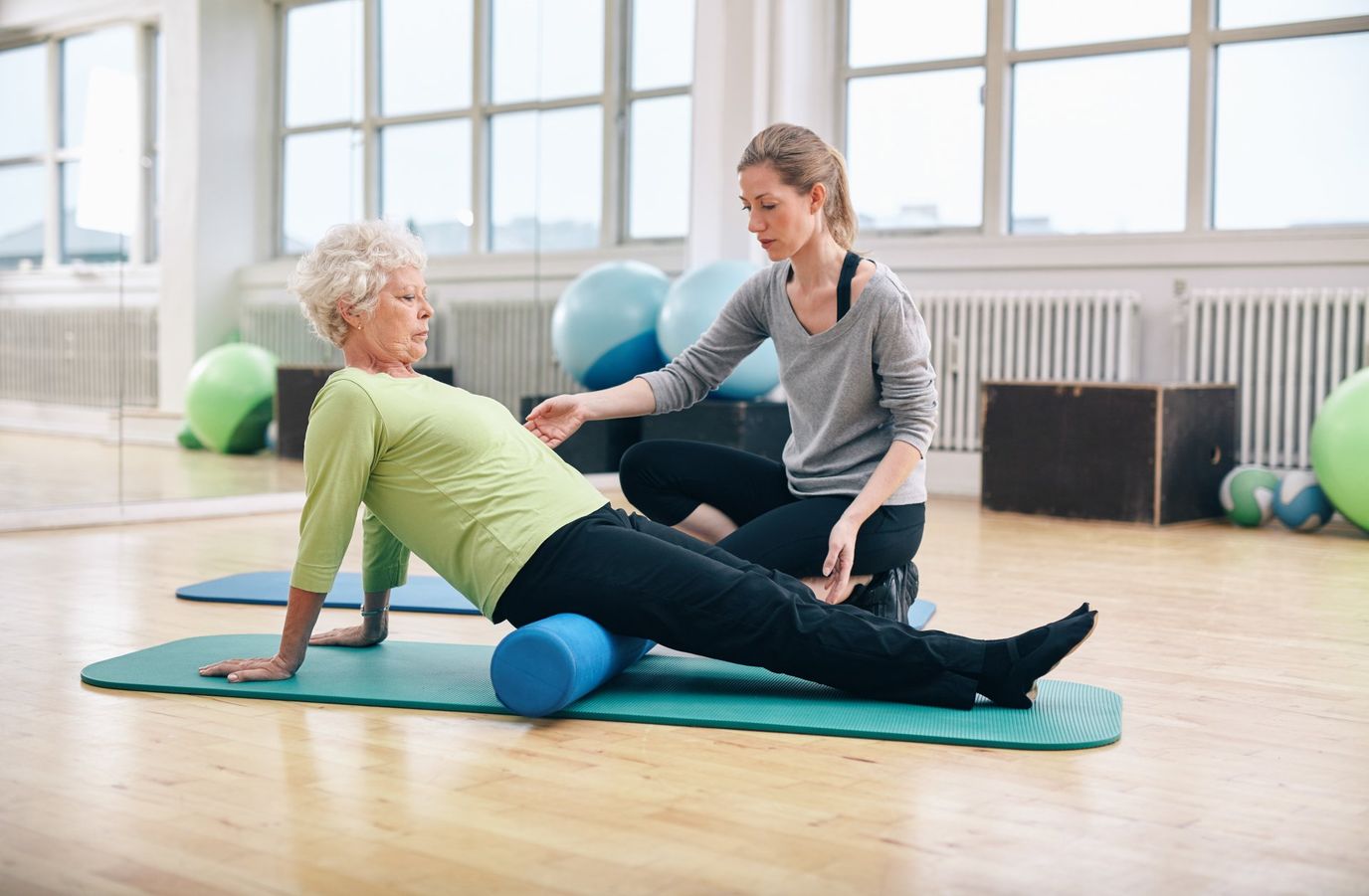 Therapist assisting a senior in a fitness class