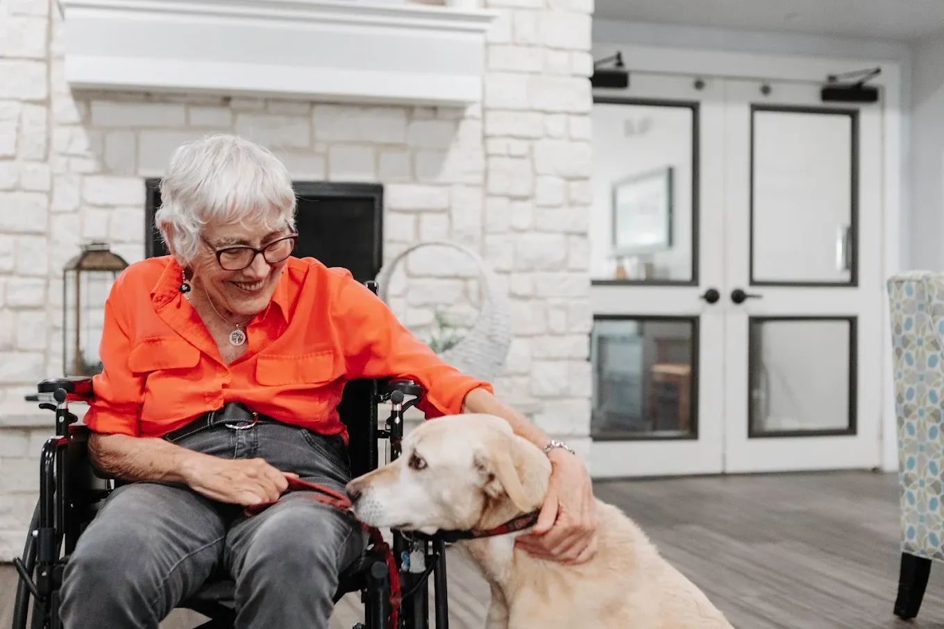 Resident enjoying time with a dog in a common area