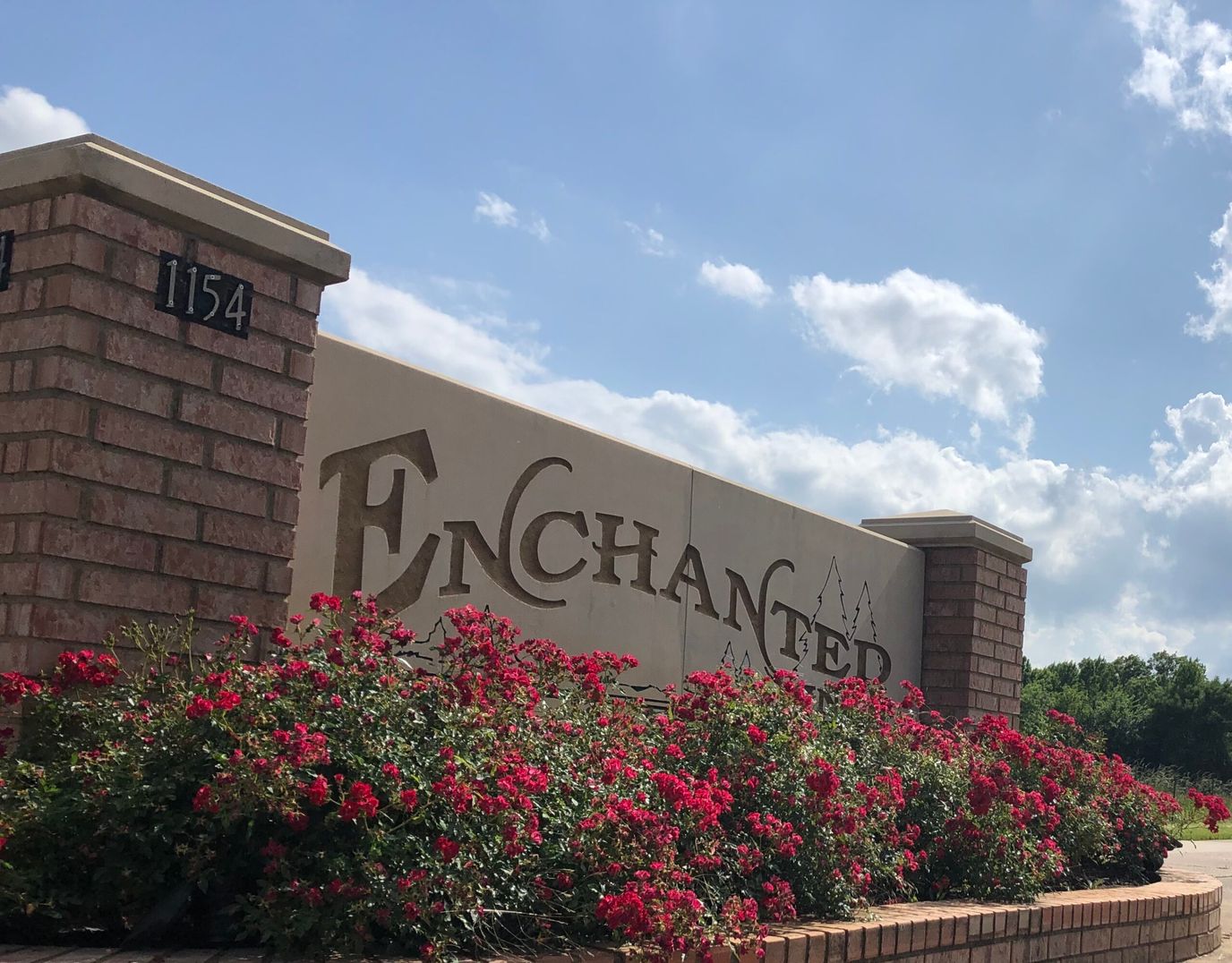 Exterior view of the Enchanted Pines entrance sign with flowers