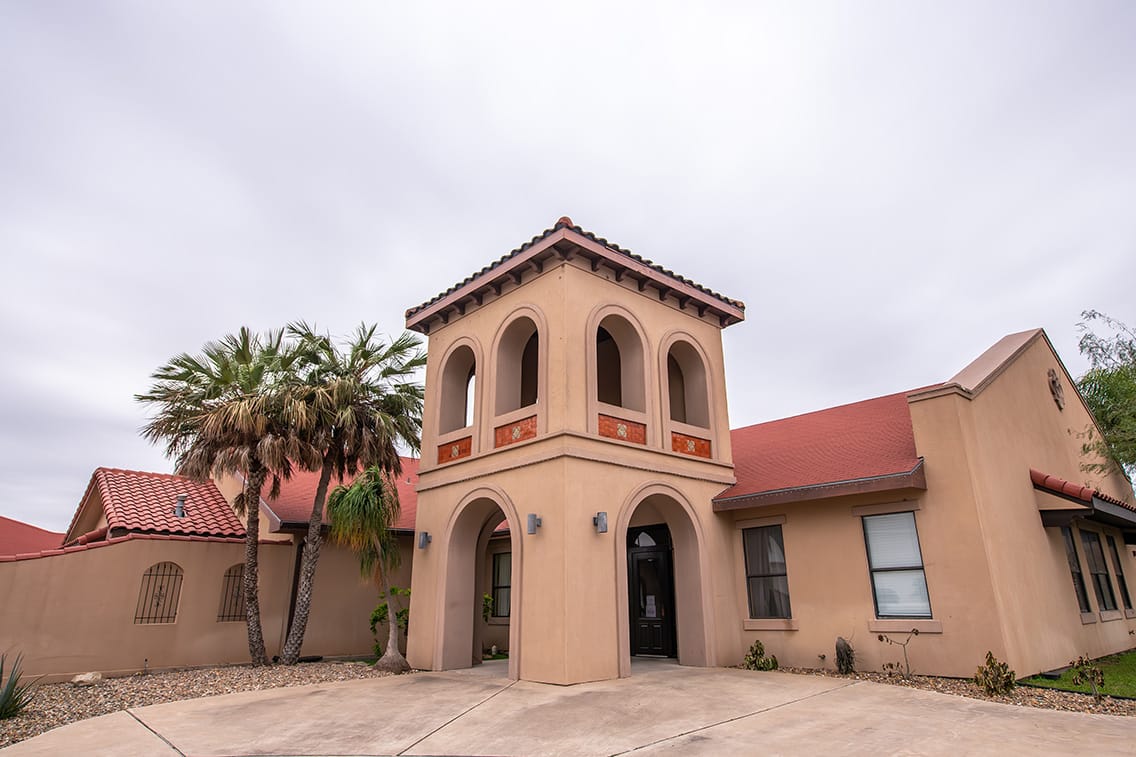 Exterior view of a senior living facility with palm trees