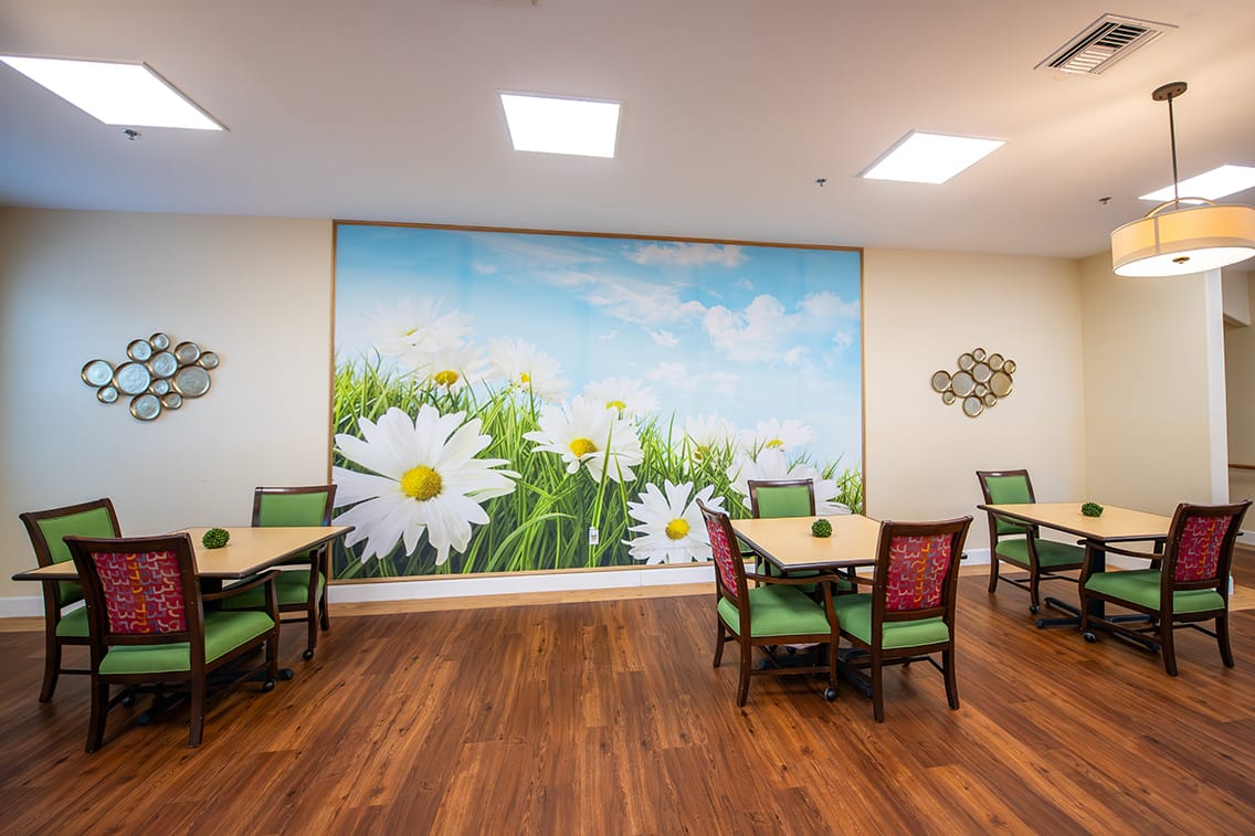 Bright activity room with floral mural and tables