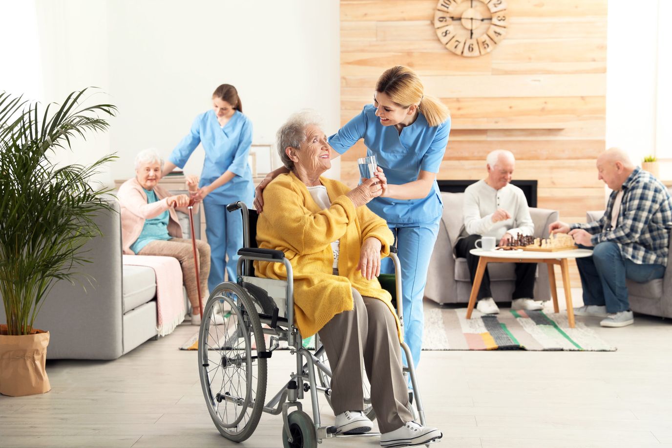 Residents engaged in activities with staff in a cozy common area