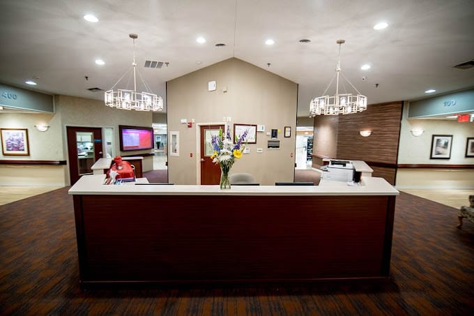 Reception area with flowers and a friendly staff member