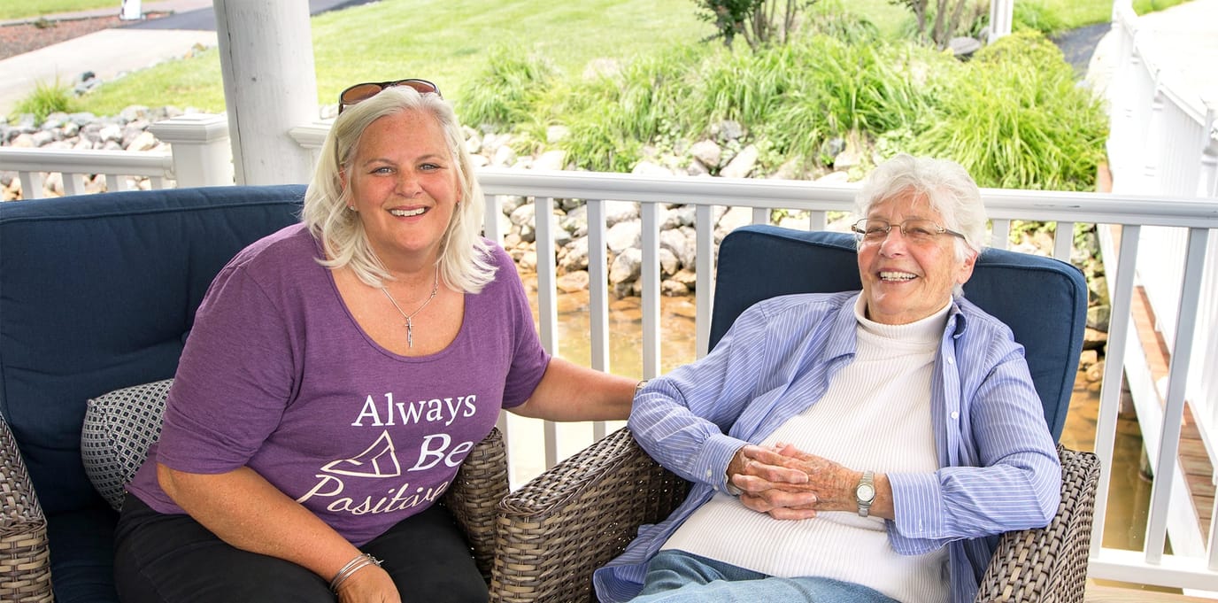 Staff member with a resident outdoors, both smiling