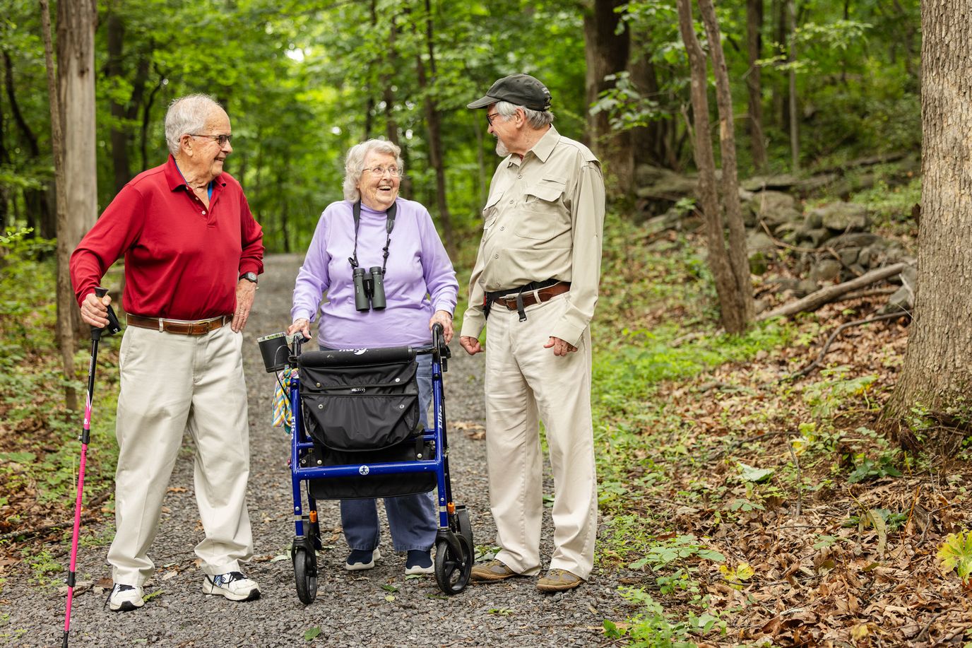Three seniors enjoying a walk on a wooded trail