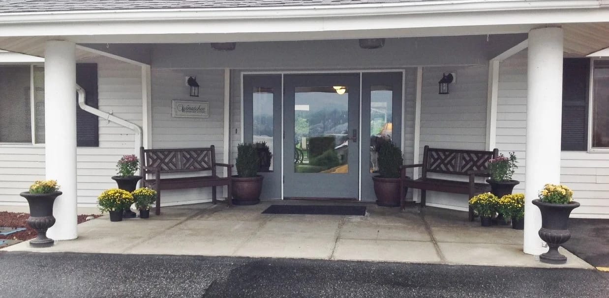 Entrance to Kadie Glen Assisted Living with benches and flowers