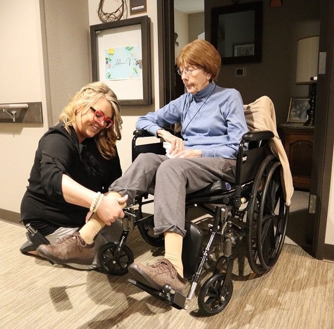 Caregiver assisting a resident in a wheelchair