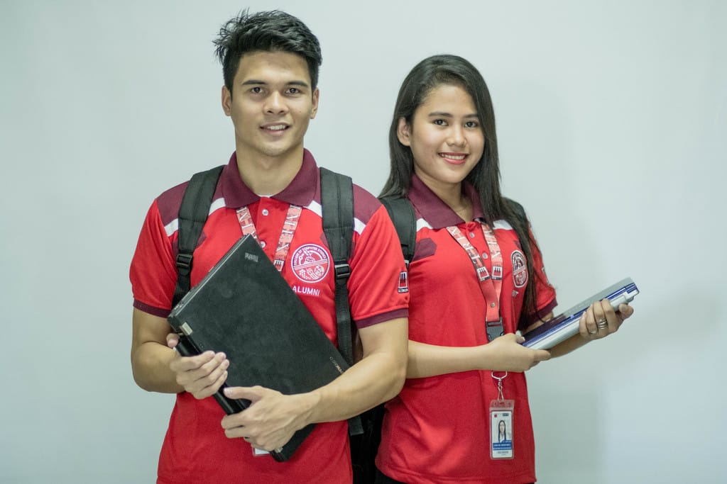 Homme Residential Wittenberg, assisted living — Two students in matching red uniforms with school supplies