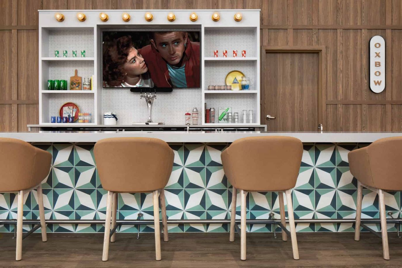 Lumia of Mequon Memory Care, assisted living in Mequon, WI — Modern bar setup with decorative wall and television
