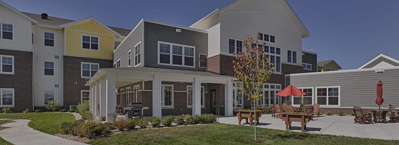 Exterior view of Kettle Park Senior Living facility with seating area