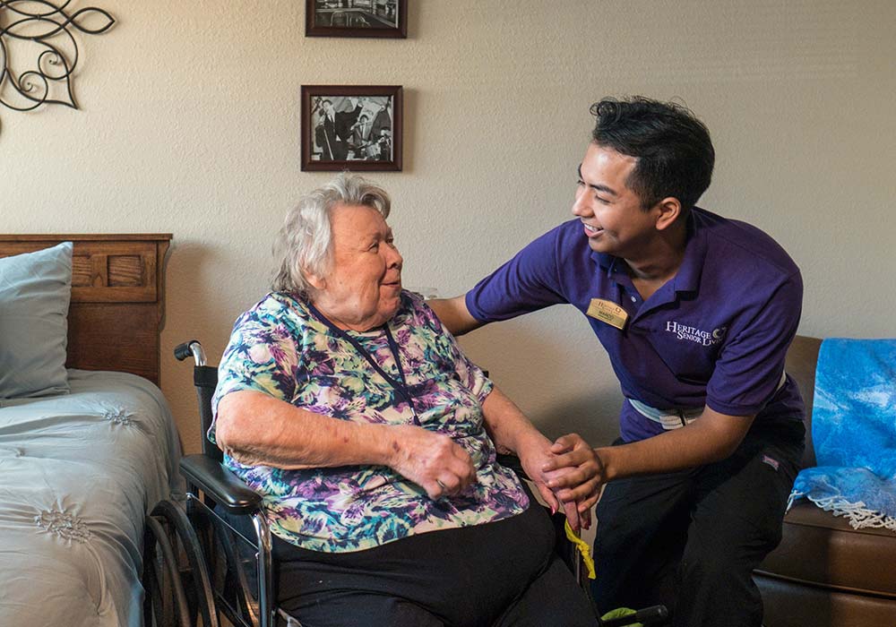 Heritage Lake Country, assisted living in Hartland, WI — Caregiver interacting with a resident in a cozy room