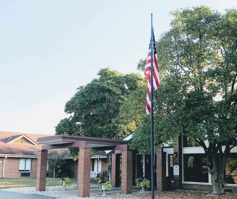 Exterior view of the facility entrance with flag