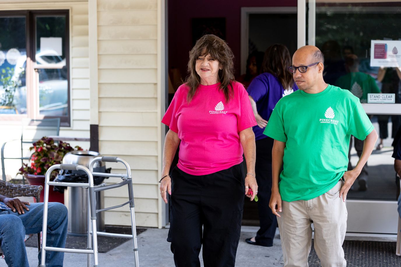 Staff members assisting residents at the entrance