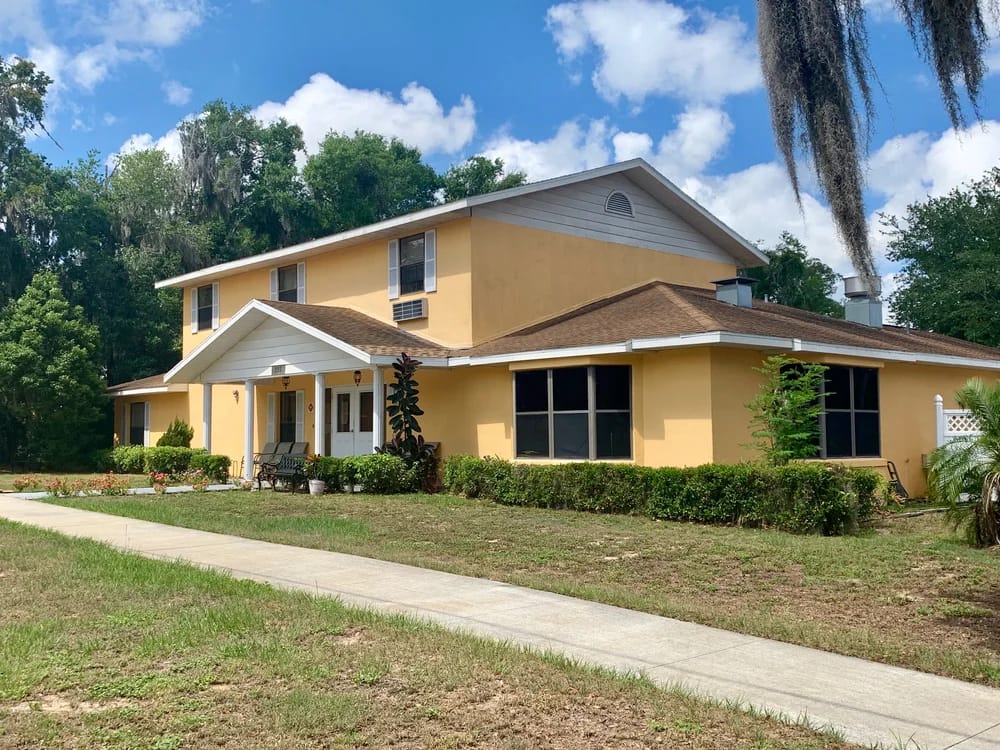 Exterior view of Eustis Senior Care building with garden