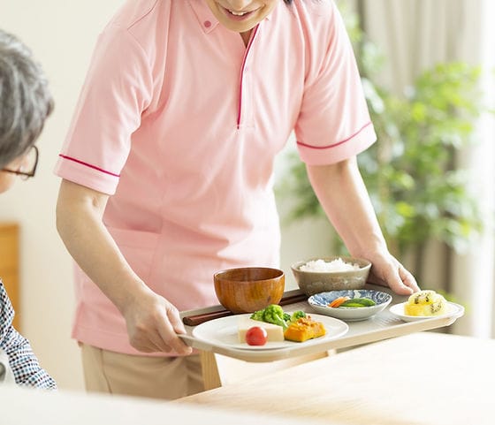 Staff serving a meal to a resident.