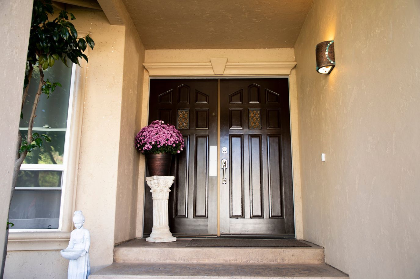 Front entrance with flower pot and statue