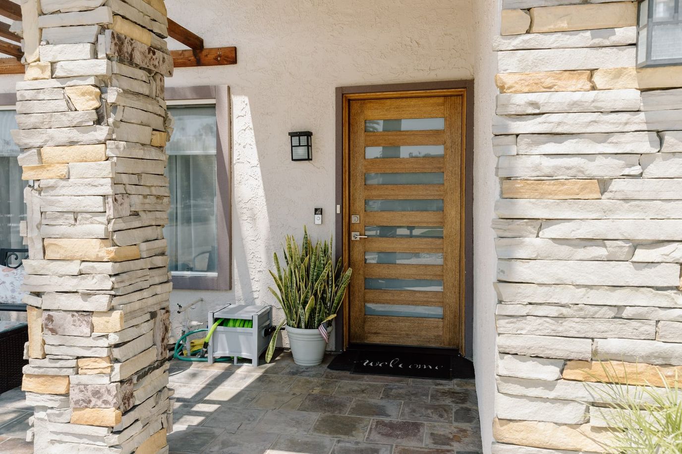 Welcoming entrance with a wooden door and stone columns
