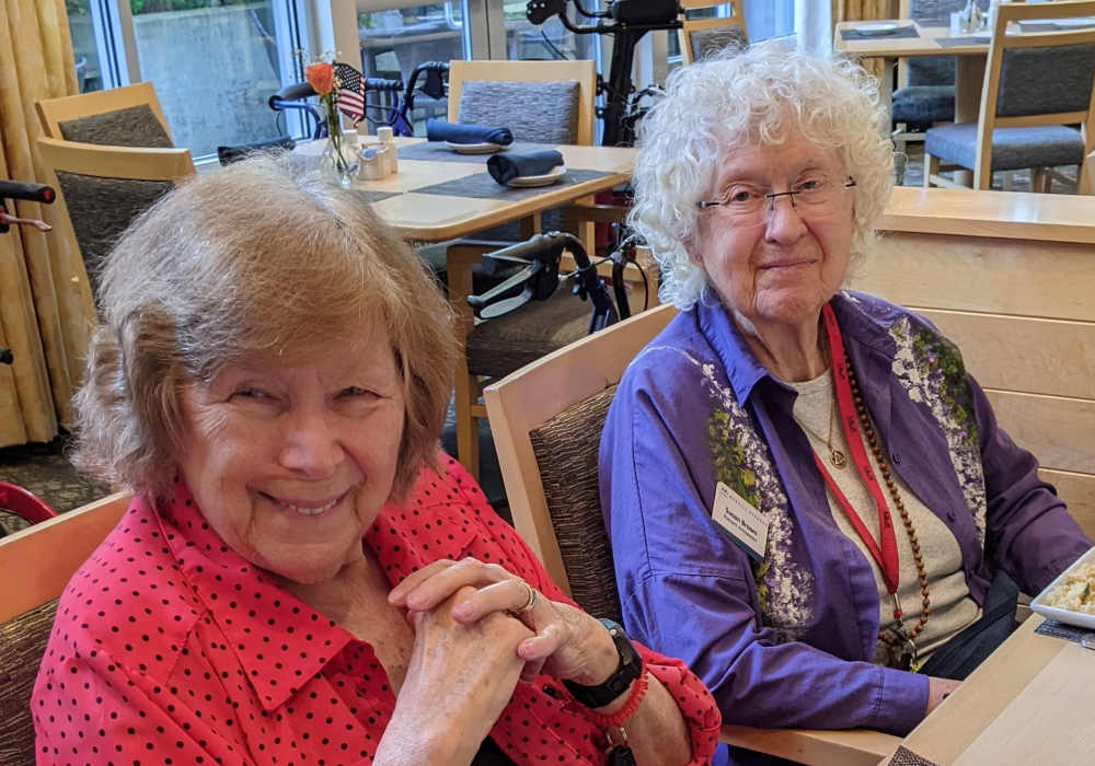 Two smiling residents enjoying a meal together