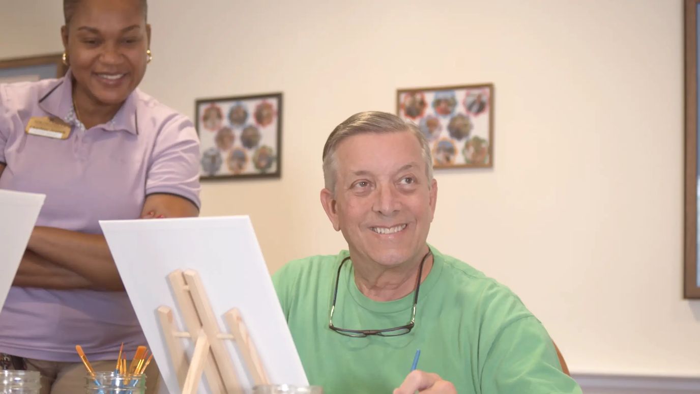 Resident participating in an art activity with staff.