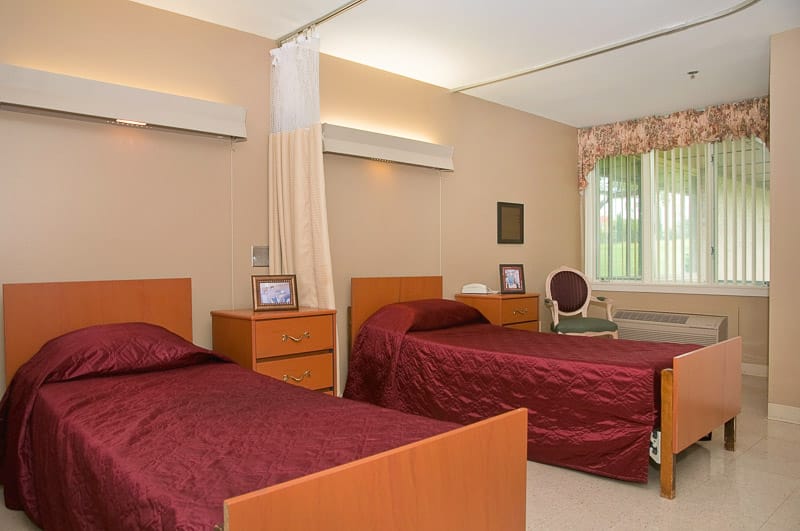 A shared resident room with two beds and personal items