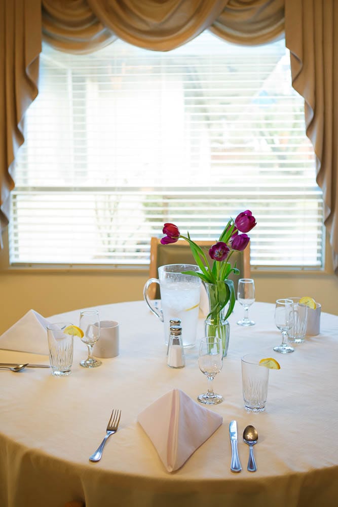 Dining table set with flowers in a bright room