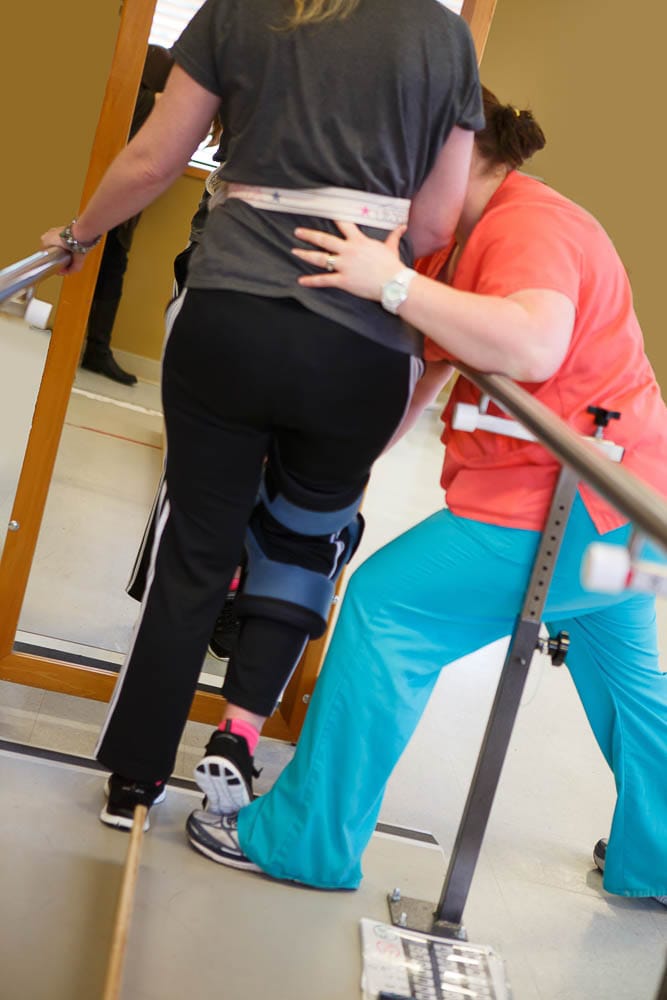 Staff assisting a resident with physical therapy