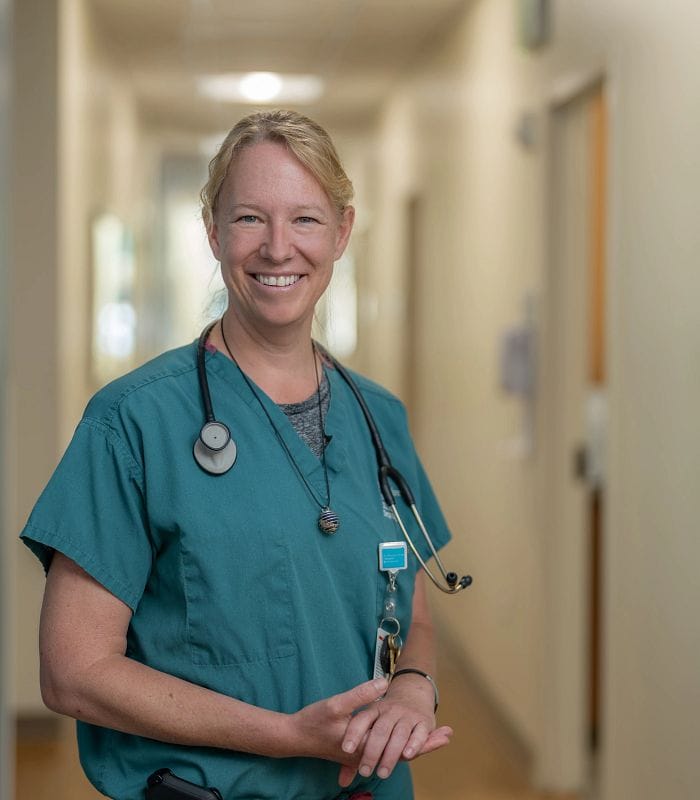Healthcare worker smiling in a facility hallway
