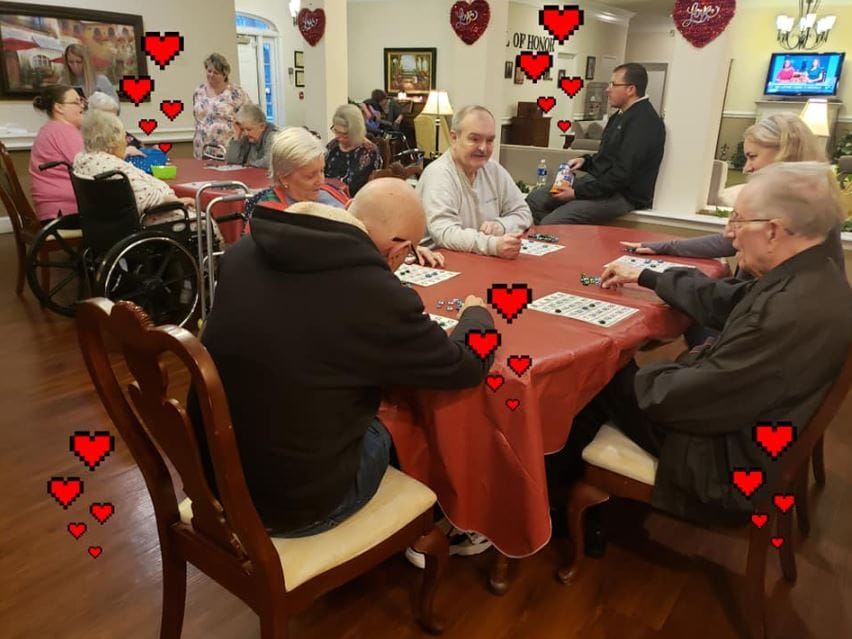 Seniors playing bingo at a game night in a cozy common area.
