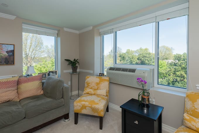 Bright living room with a couch, armchair, and windows