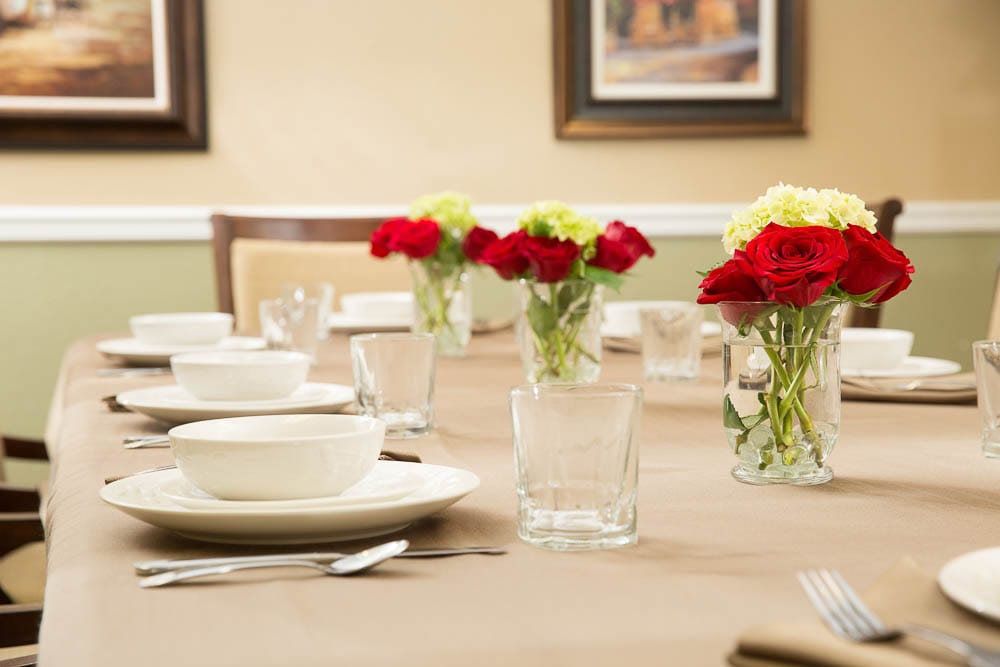 Well-set dining table with flowers and dishes