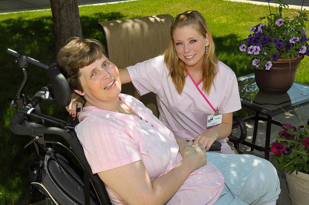 Caregiver assisting a resident in an outdoor setting