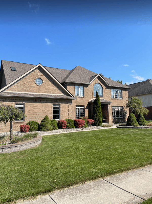 Residential exterior of a brick building with landscaping.