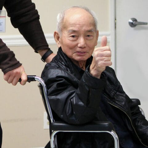 Resident giving a thumbs up in a wheelchair