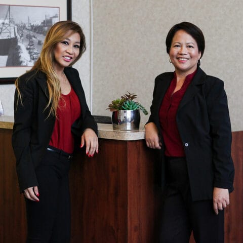 Two staff members posing in an indoor setting