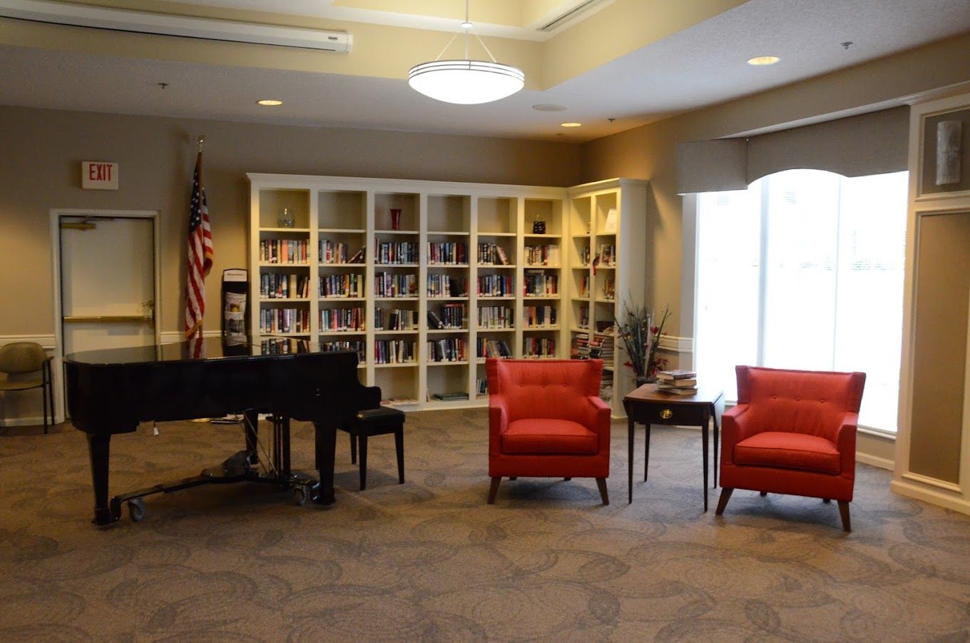 Library with a piano and red chairs