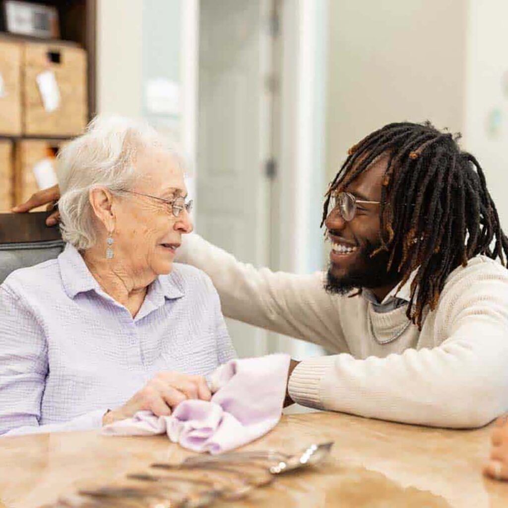 A staff member engaging with an elderly resident in a warm setting