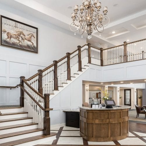 Bright, welcoming lobby with elegant staircase and chandelier