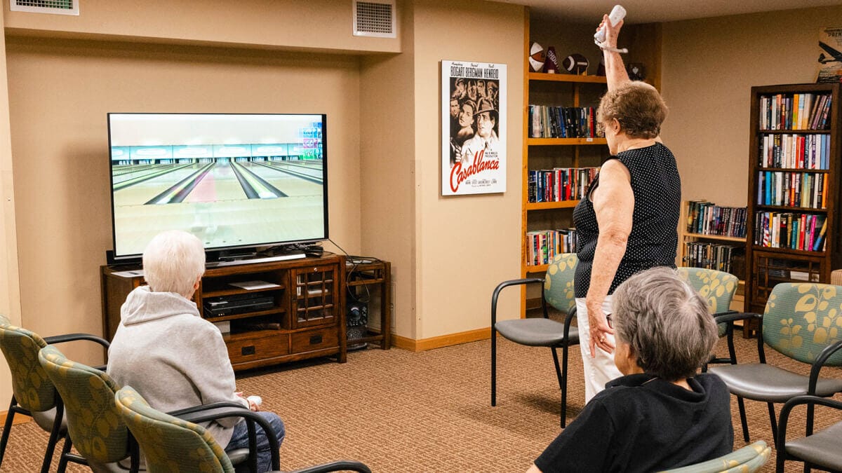 Seniors enjoying a bowling activity on a screen